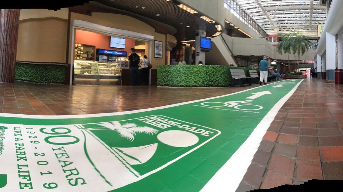 Foto del interior de un pasillo en el cual se muestra una alfrombra verde simbolizando el mes de la recreación