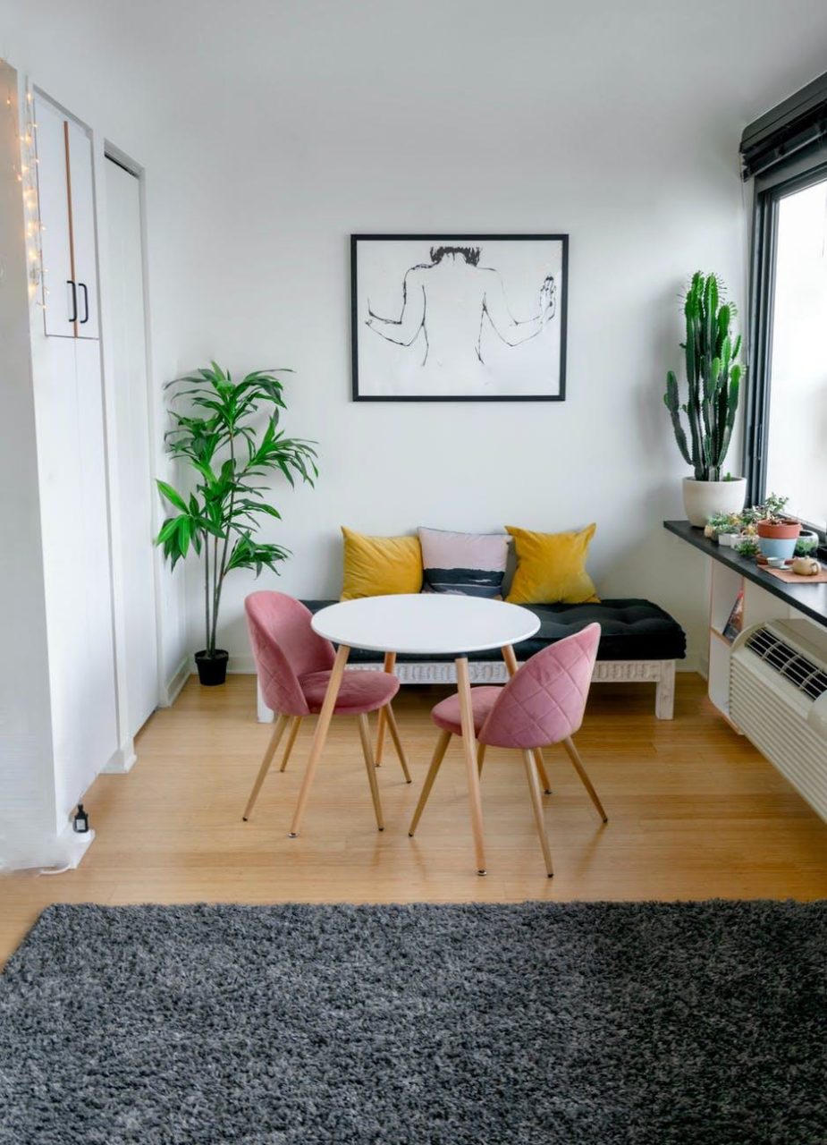 A small, cozy apartment with a framed art piece on the wall and minimalist furniture.