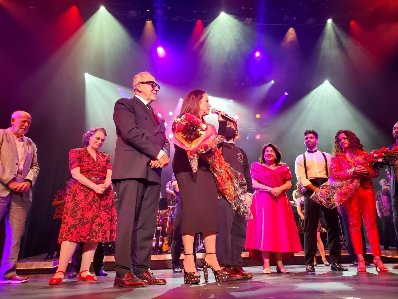 Gloria and Emilio Estefan accept a bouquet on stage.