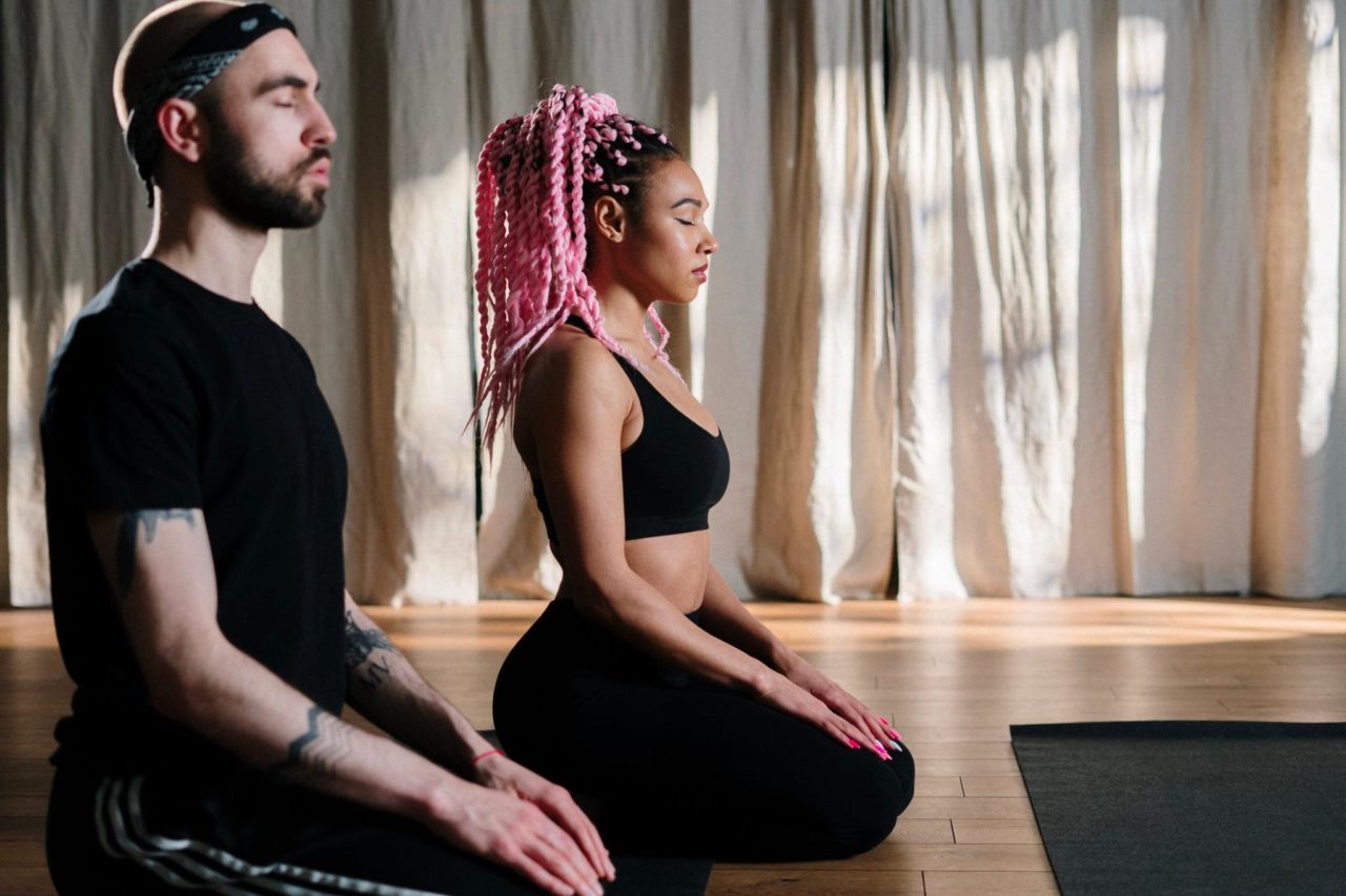 Two people meditate during a calming yoga practice in Miami.
