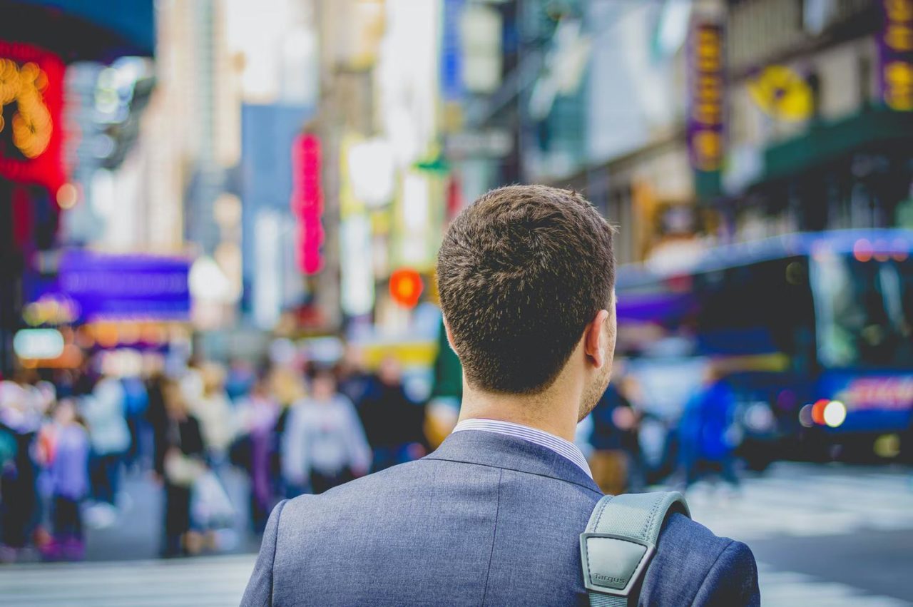 A young man standing in a new city during a business trip.