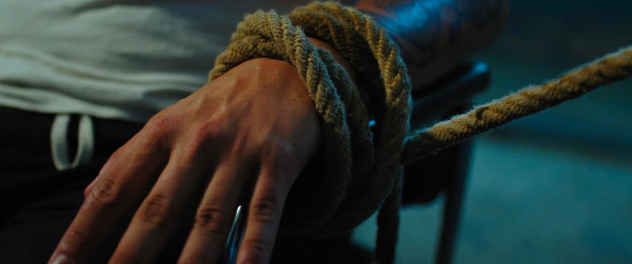 La mano de una persona atada a la fuerza a una silla durante un secuestro.