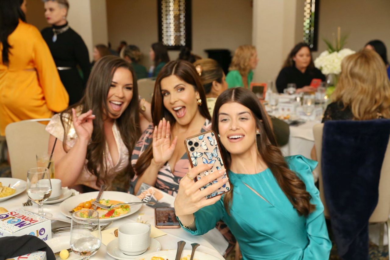 Los invitados posan para una selfie, sonriendo a la cámara.