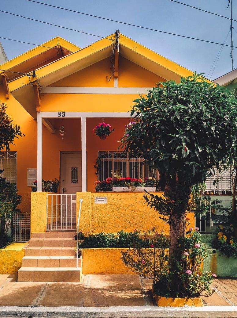 A small, brightly colored, cozy home with a yellow facade.