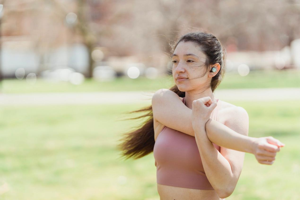 A woman stretches her arm across her chest following a workout.