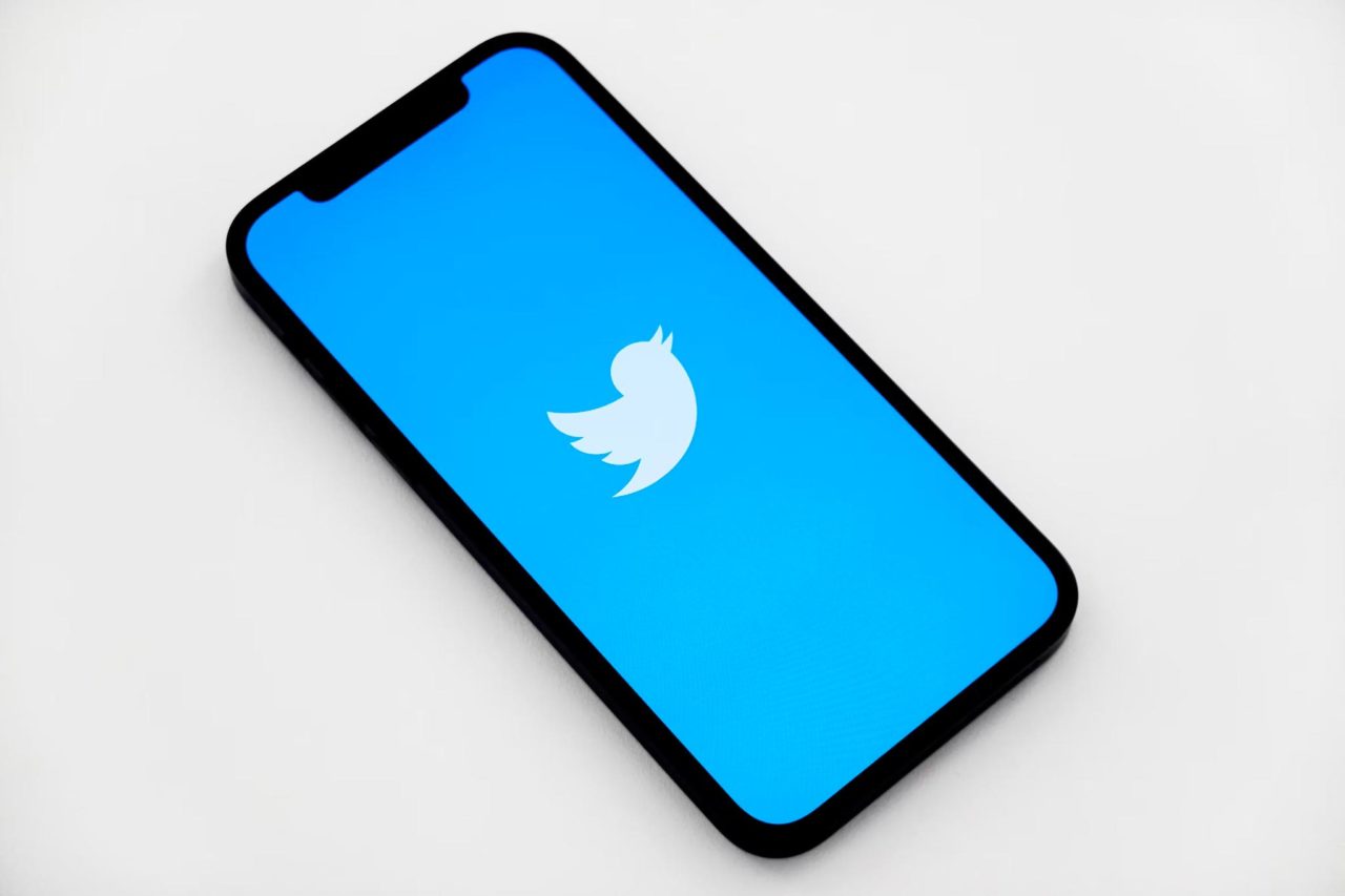 A person's phone screen with the Twitter logo on the screen.