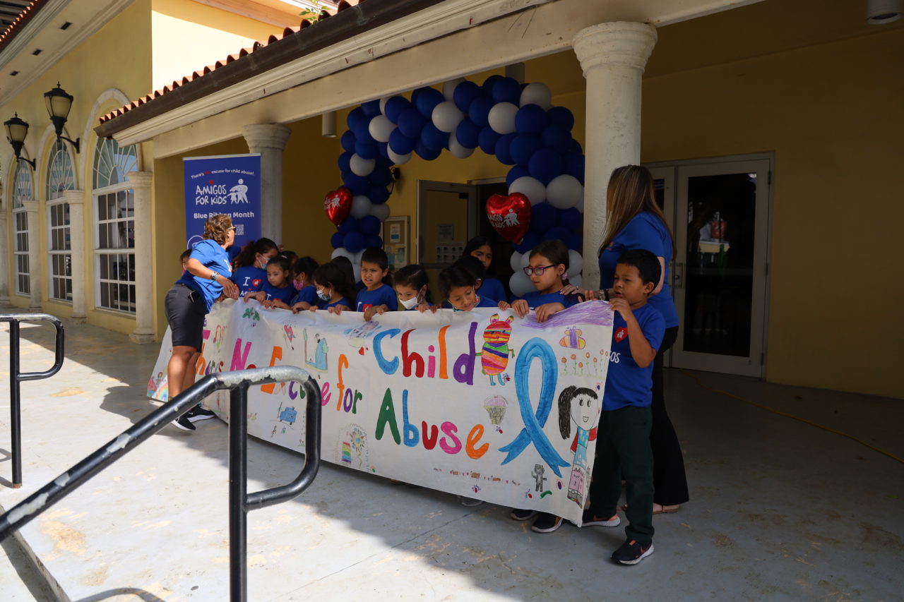 Children holding banner during child abuse event