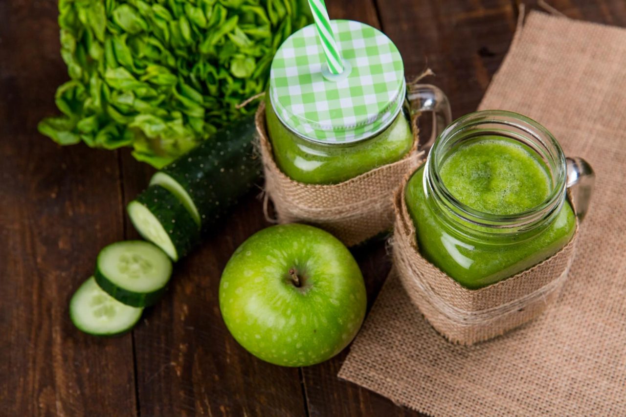Two mason jars and various ingredients for popular detox drinks and diets.