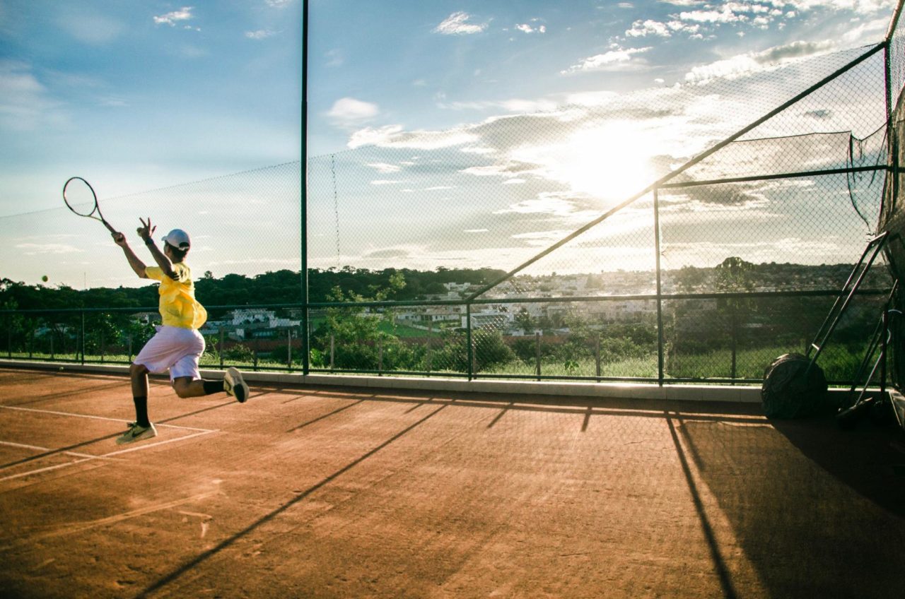 Un jugador de tenis en el Abierto de Miami la cancha, saltando alto para golpear la pelota.