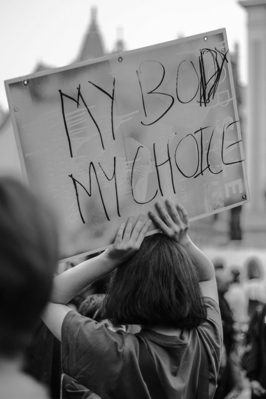 una foto en blanco y negro de un manifestante que sostiene un cartel que dice "Mi cuerpo es mi elección".