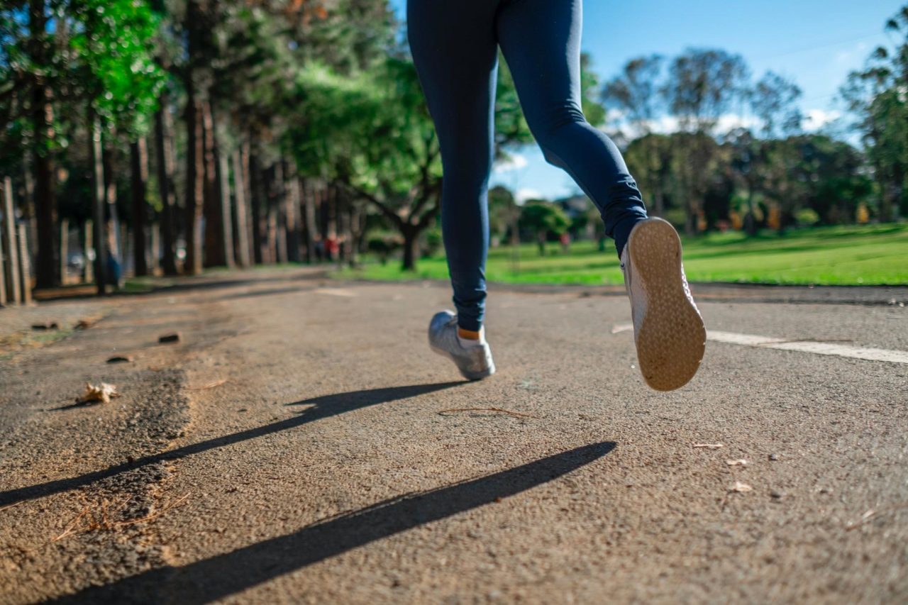 A woman runs outdoors while training for a sport.