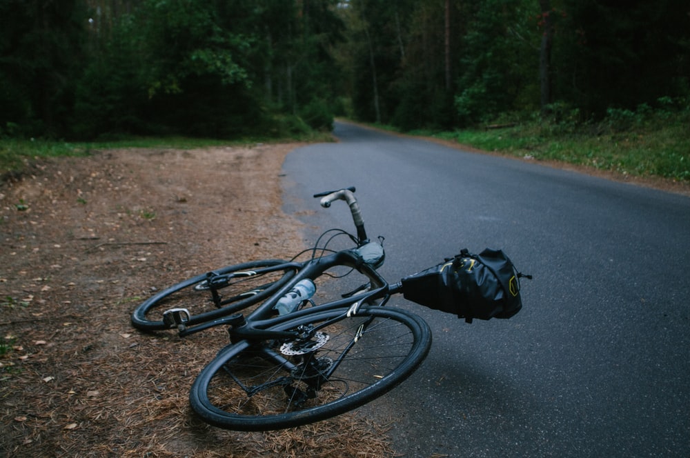 A bicycle lying on an empty road.