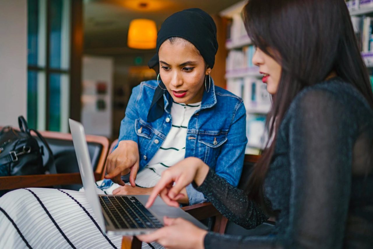 Two women business owners sit and have a meeting together.
