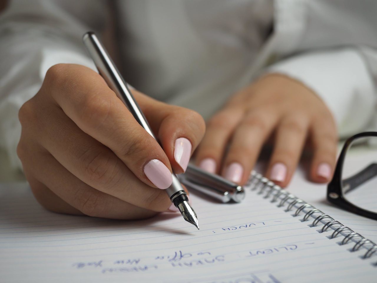 la propietaria de un negocio toma notas y escribe contenido en su diario.