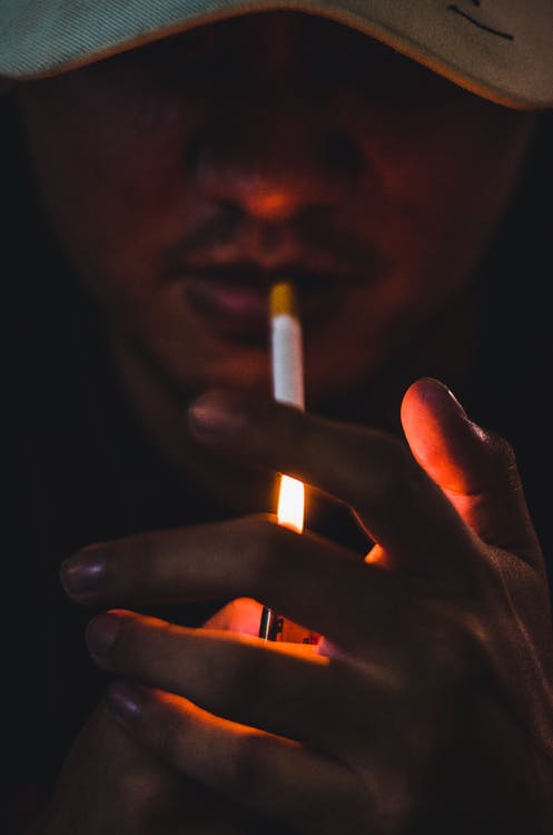 A person lighting a cigarette.