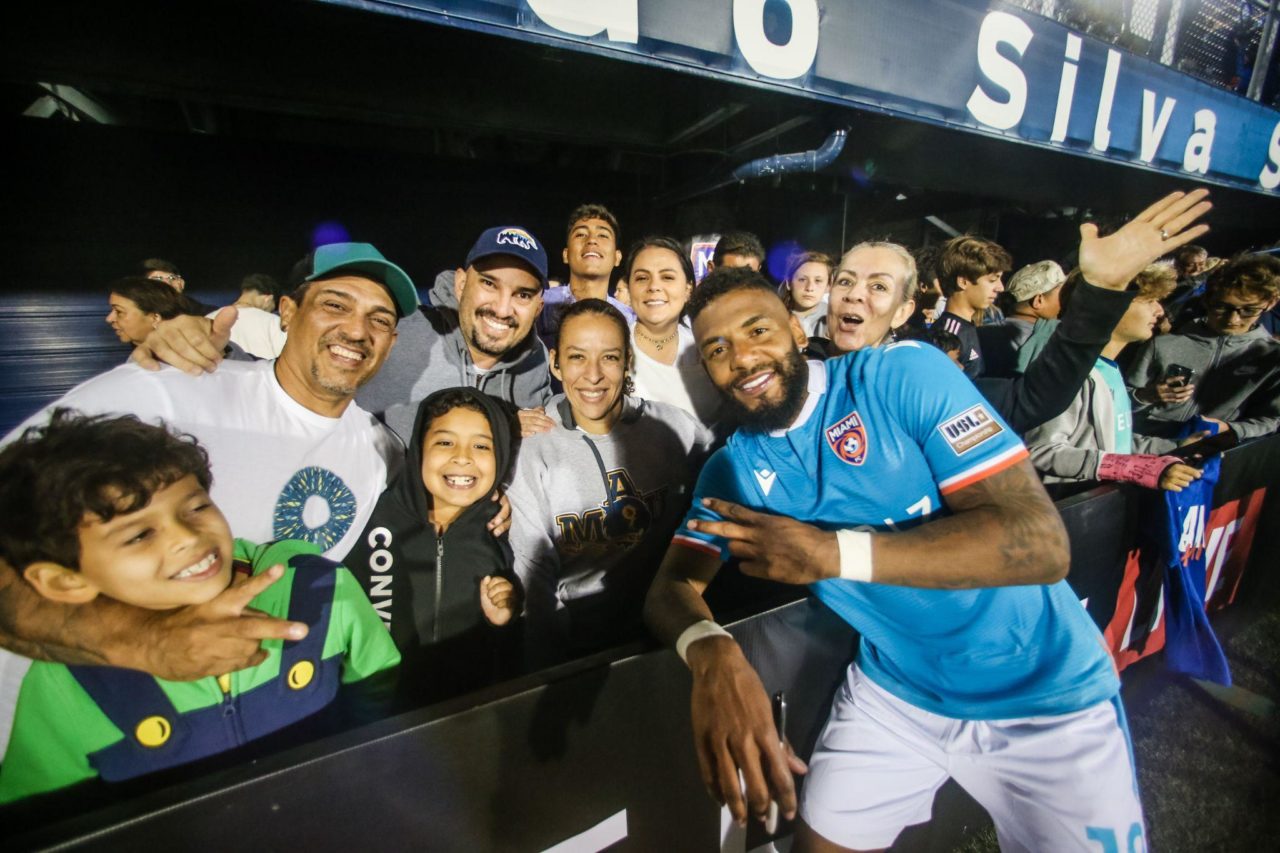 A player from Miami FC poses for a picture with excited fans.