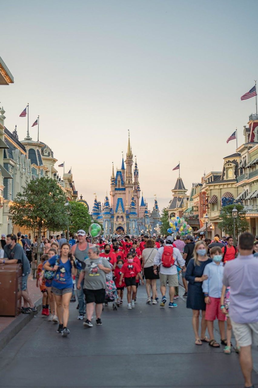 Decenas de turistas caminan por Disney World durante un día ajetreado.