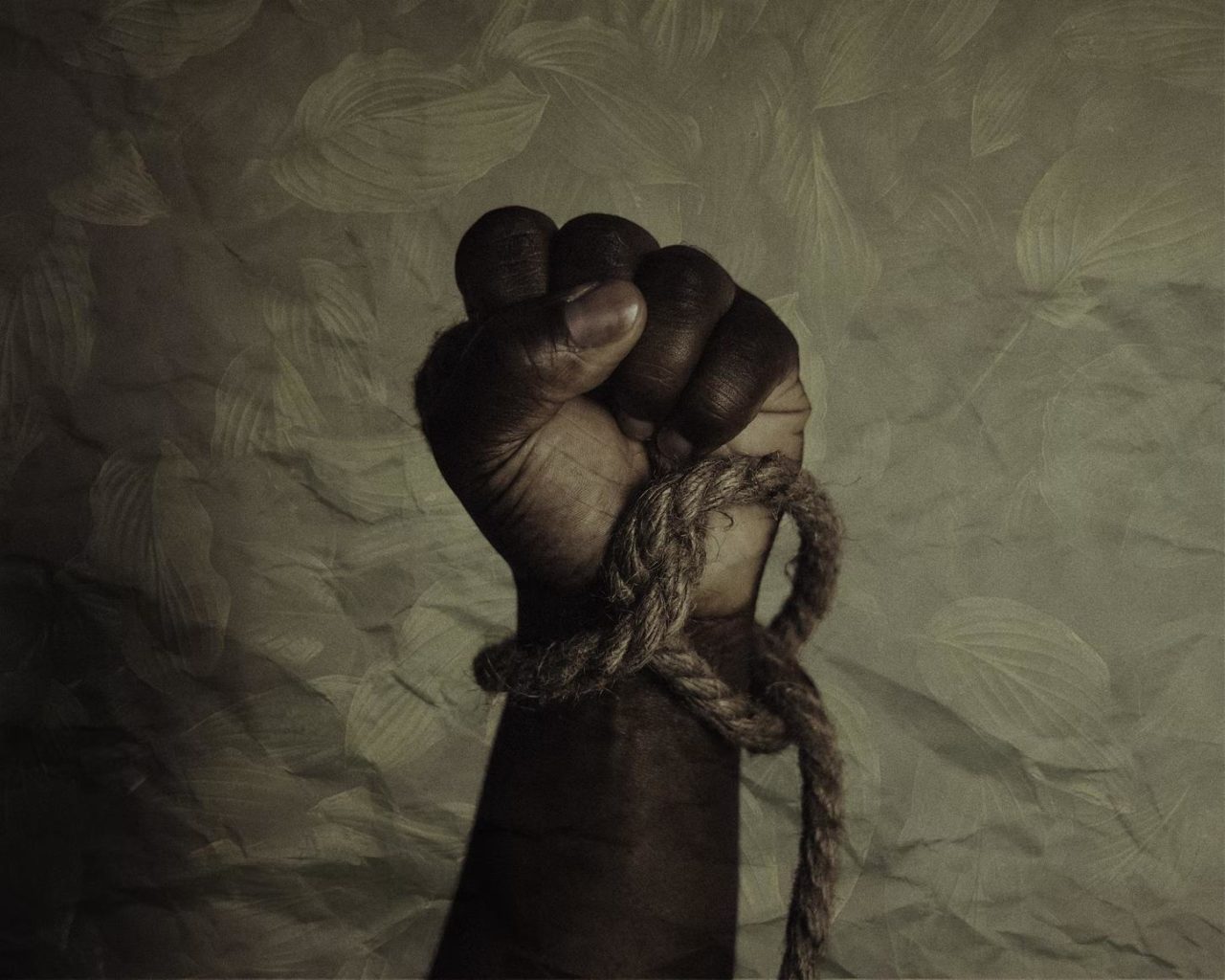 A symbolic picture of a black person’s hand with rope on the wrist, indicating freedom.