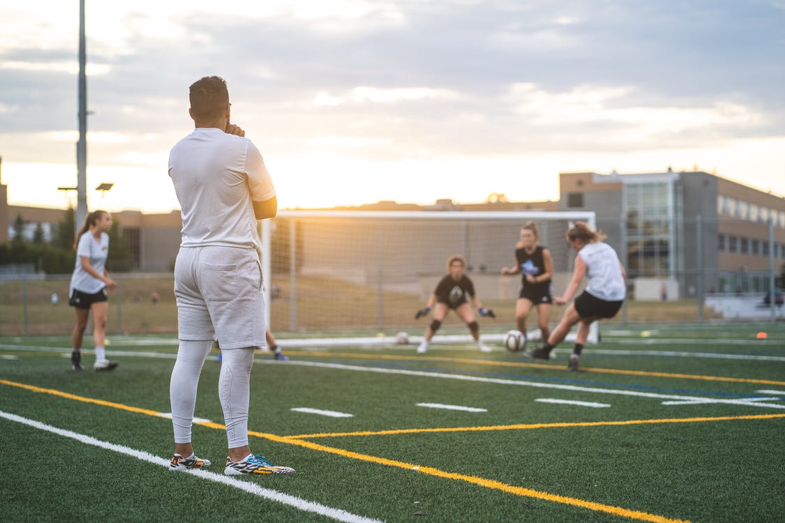 A coach watching over a kids' football game.
