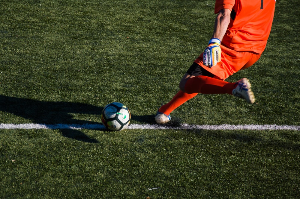 un jugador de fútbol pateando la pelota en el campo