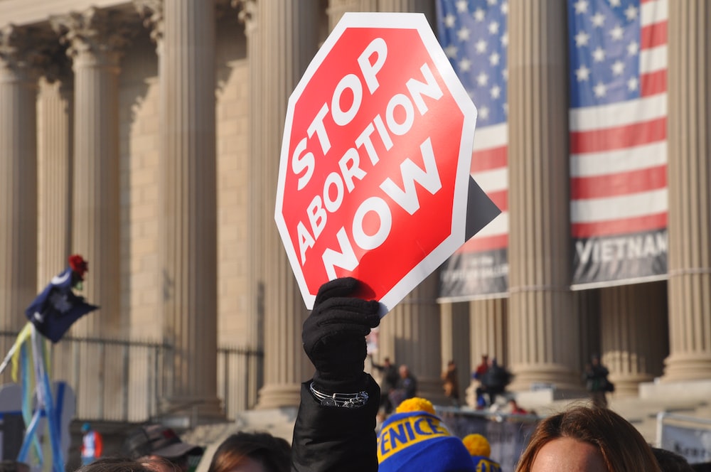 A person holding a sign with Stop Abortion