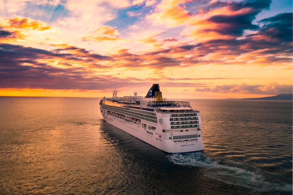 a cruise ship sailing on the sea during a sunset
