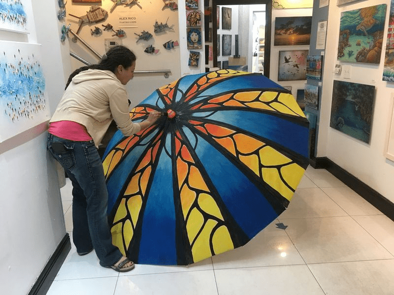 An artist painting an umbrella.