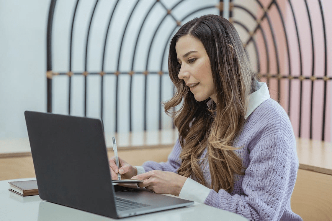 Una persona tomando notas desde su computadora portátil.