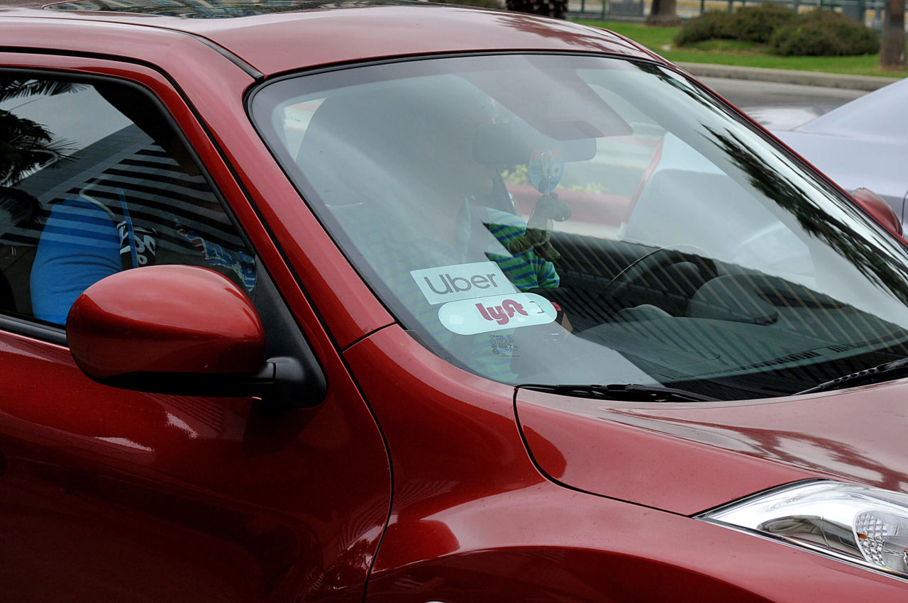 A red car with uber and lyft sticker