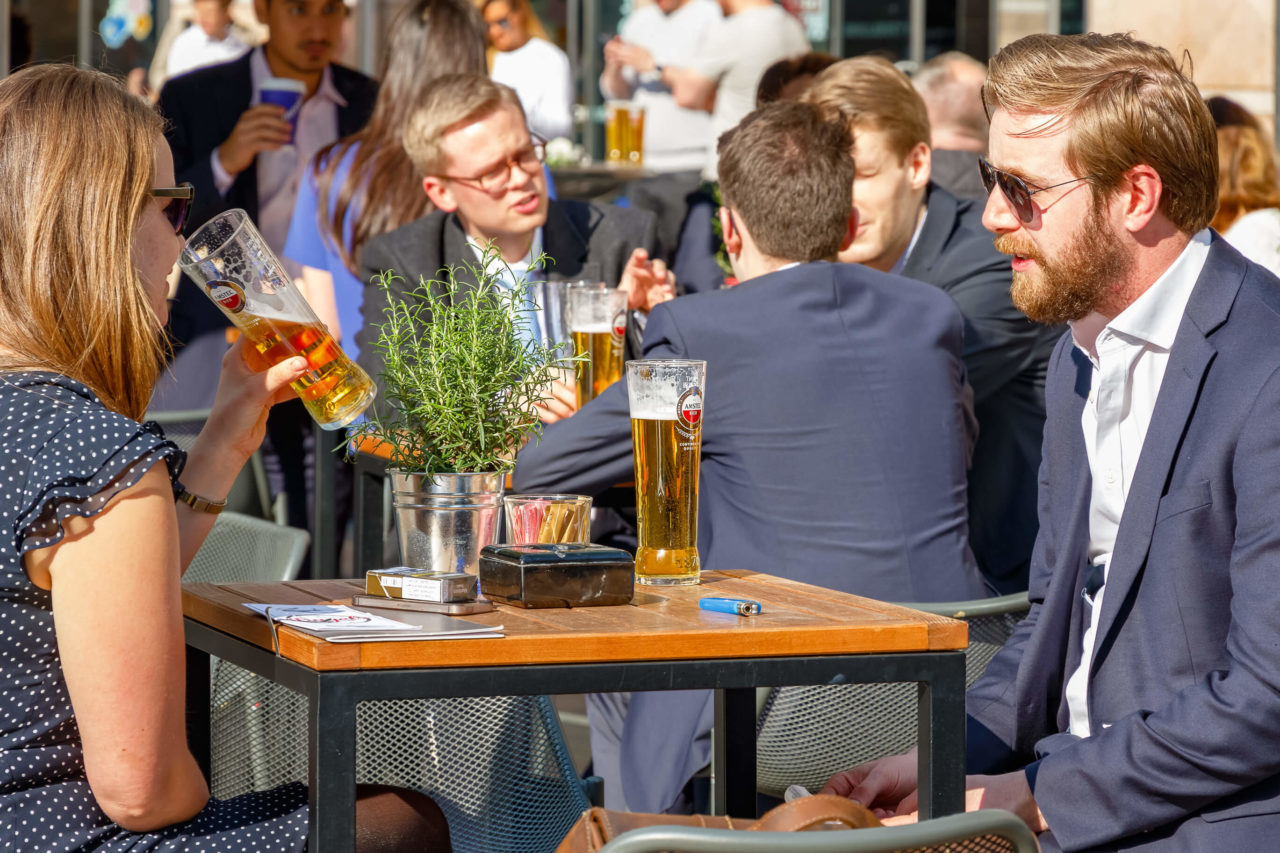 Gente sentada en un restaurante al aire libre bebiendo cerveza