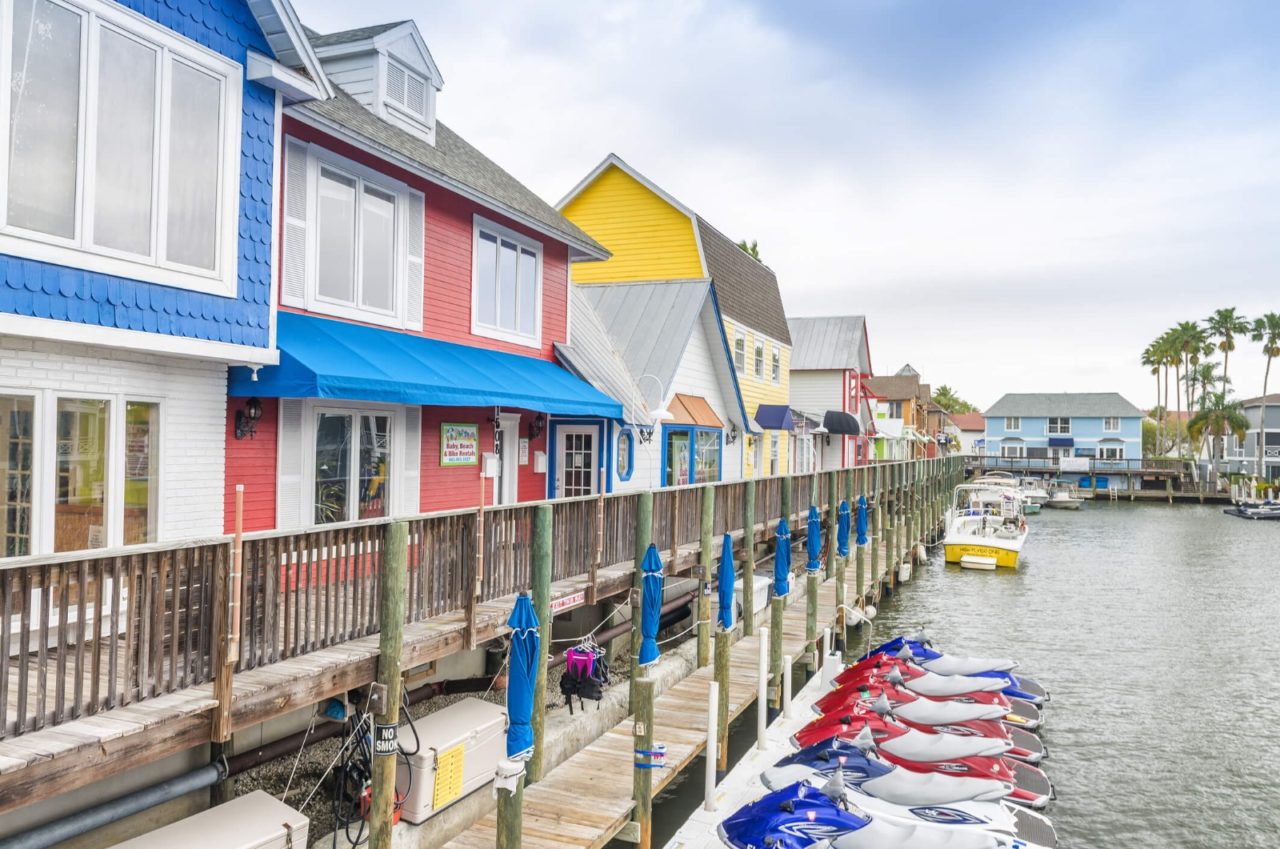 vista por los muelles con motos acuáticas y barcos y edificios coloridos