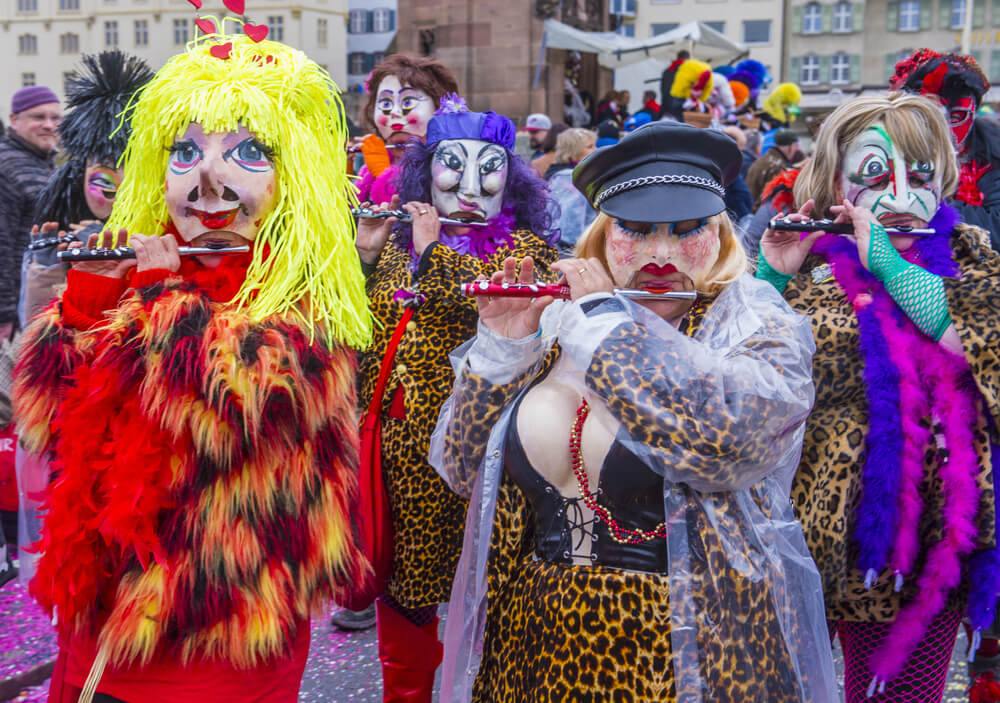 People dressed up as clown playing flutes in a parade