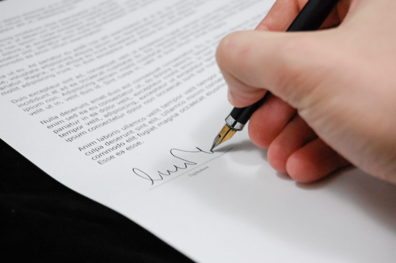 A person signing a paper