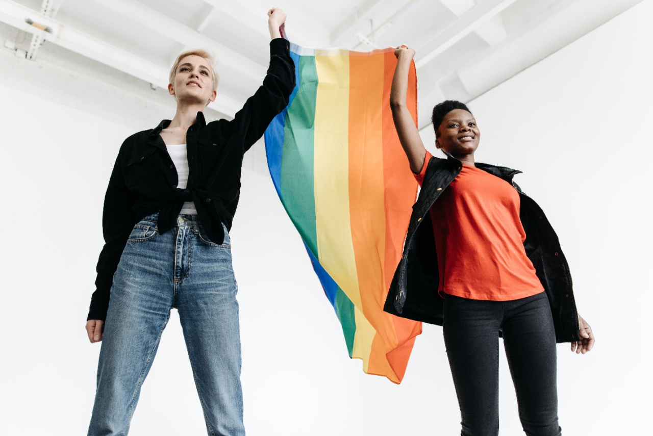 Two people holding the pride flag