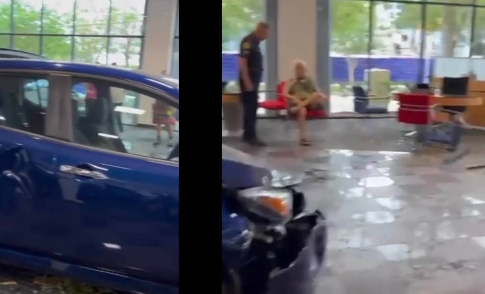 Crashed blue car inside dealership.