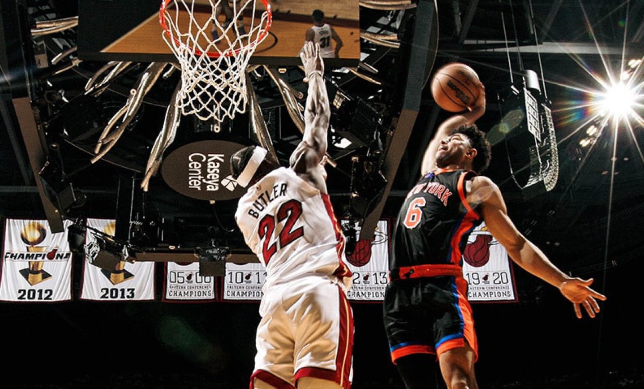 Jugador de baloncesto que intenta hacer una volcada mientras el defensor se detiene