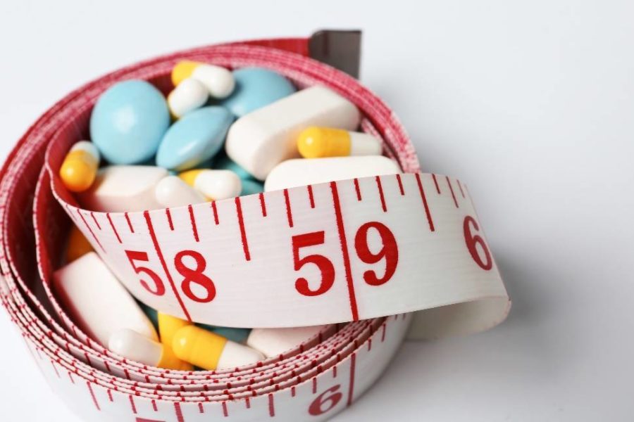 Pills with a measuring tape wrapped around them