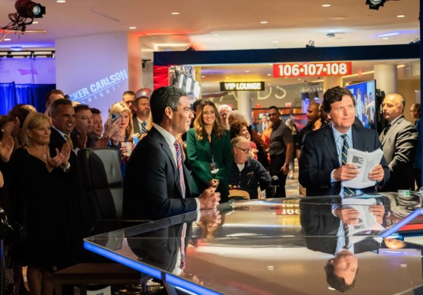 News room, people standing behind tv anchors