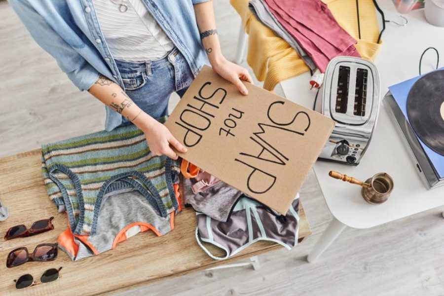 Person holding sign swap not shop with table in the background