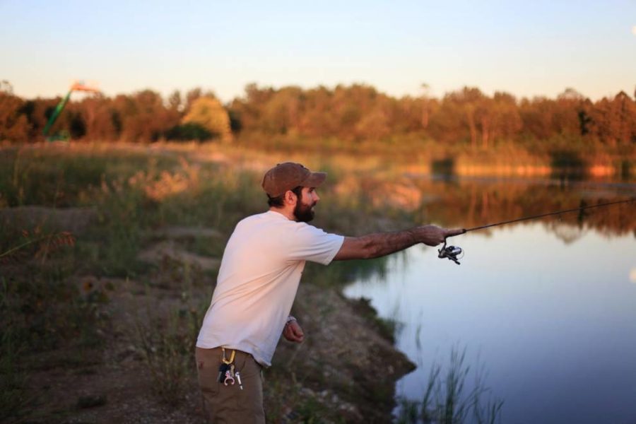 un hombre pescando cerca de un campo de hierba