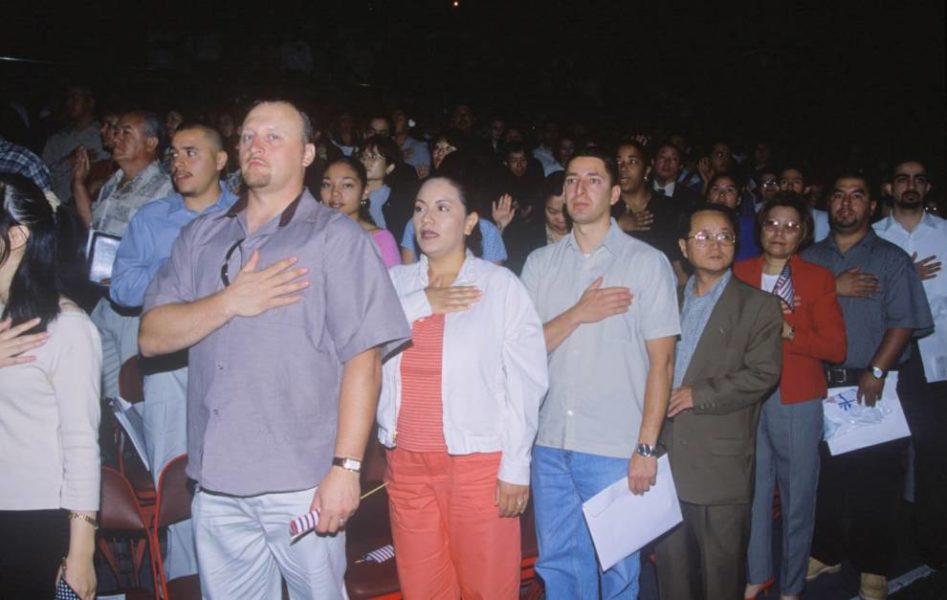 Personas que defienden el respeto al himno nacional con las manos en el corazón