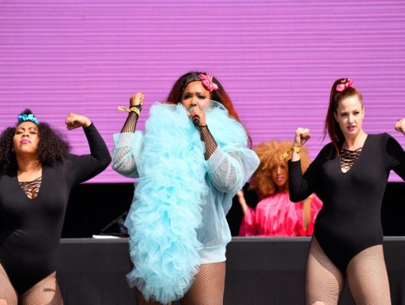 Lizzo actuando con bailarines en el escenario