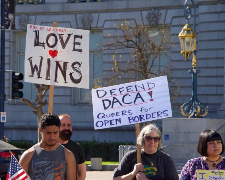 Defensores de DACA sosteniendo un cartel