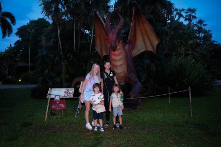 People posing for picture in front of Chupacabra statue