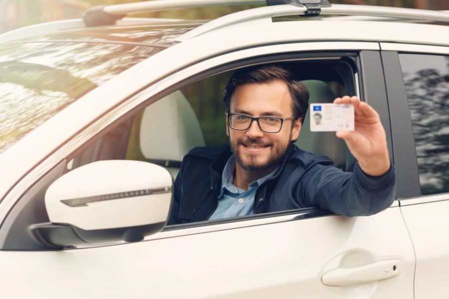 Person showing their license card while sitting in the car.
