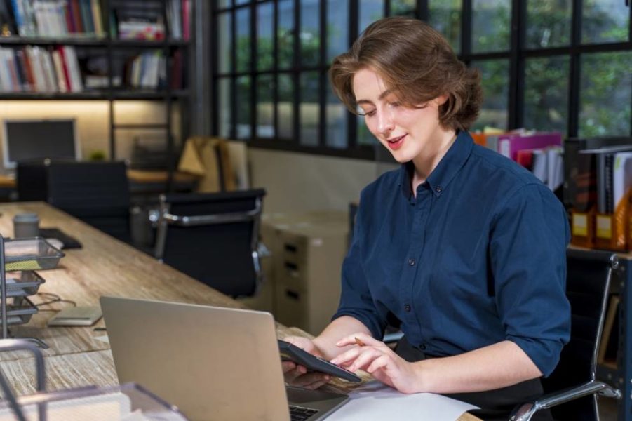 una persona que usa una computadora portátil y una calculadora