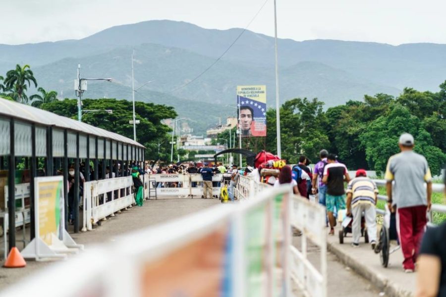 Multitud caminando por la acera cerca de una parada de autobús