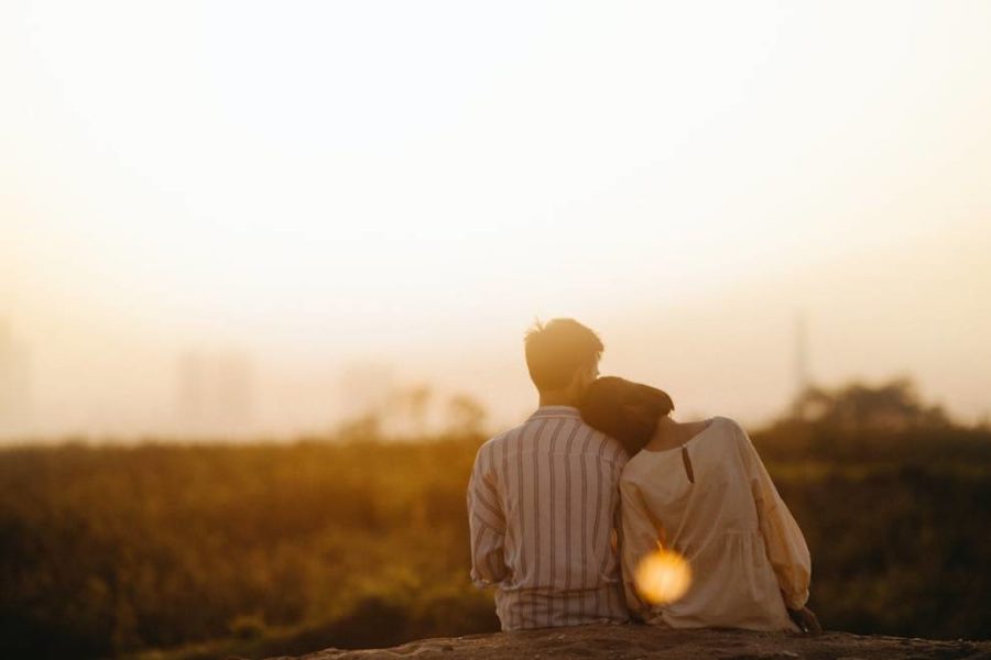 Man and woman sitting on the grass field