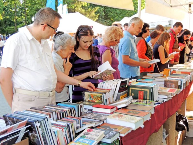 A bustling book fair with people engrossed in browsing through a wide array of books
