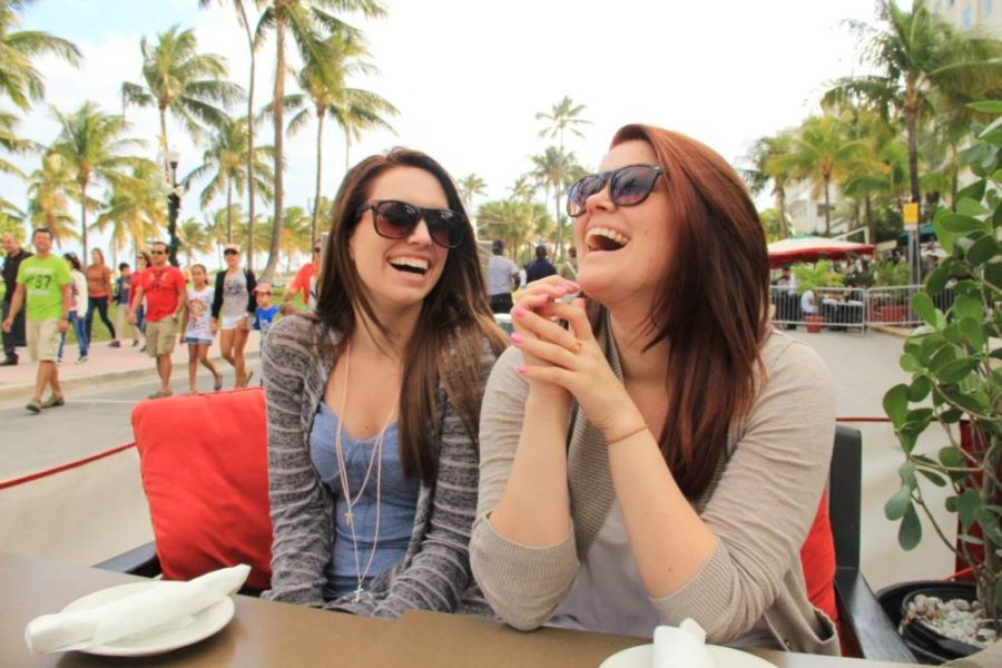 Dos mujeres con gafas de sol sentadas en una mesa